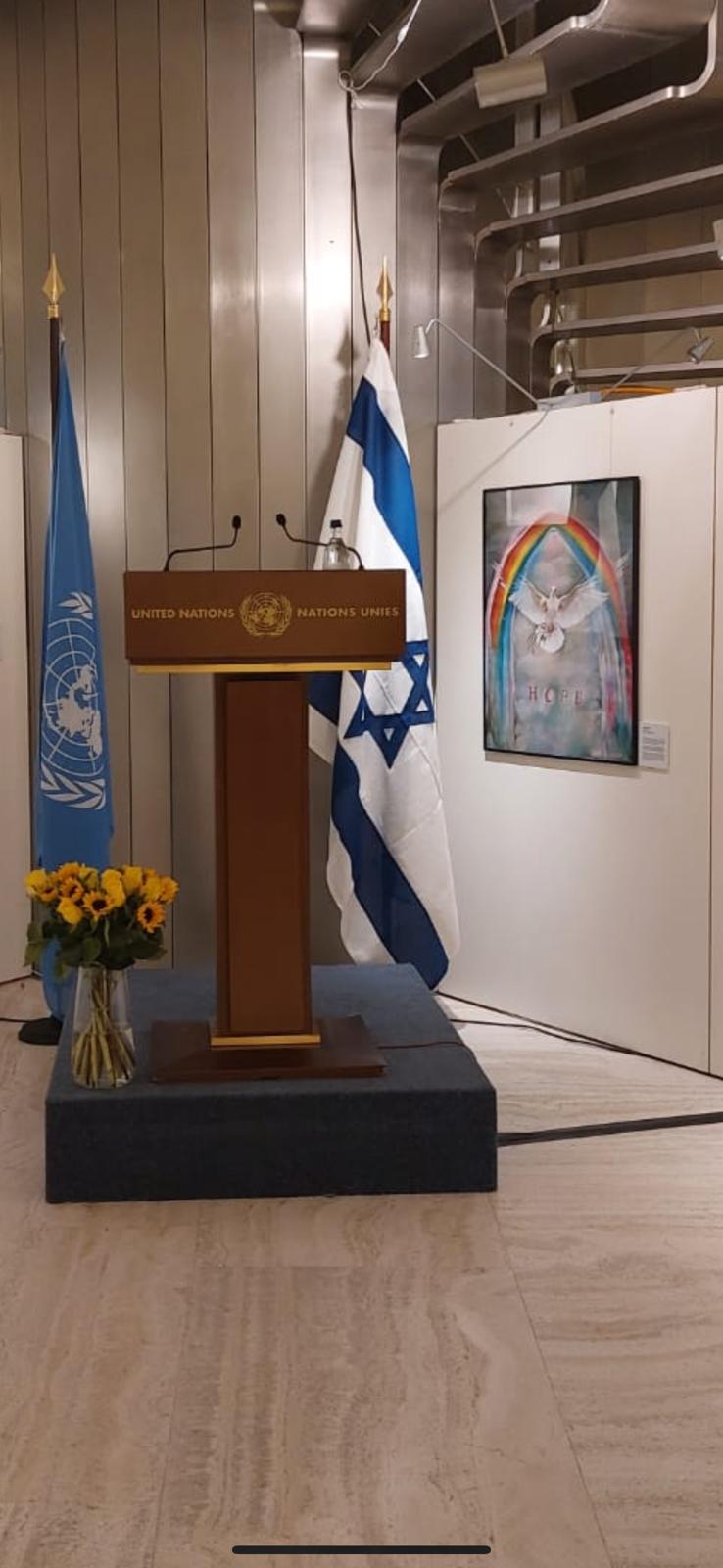 Mercy's Gate hanging beside the United Nations podium and the Israeli flag